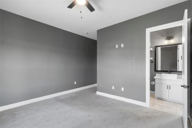 an empty room with a ceiling fan and window