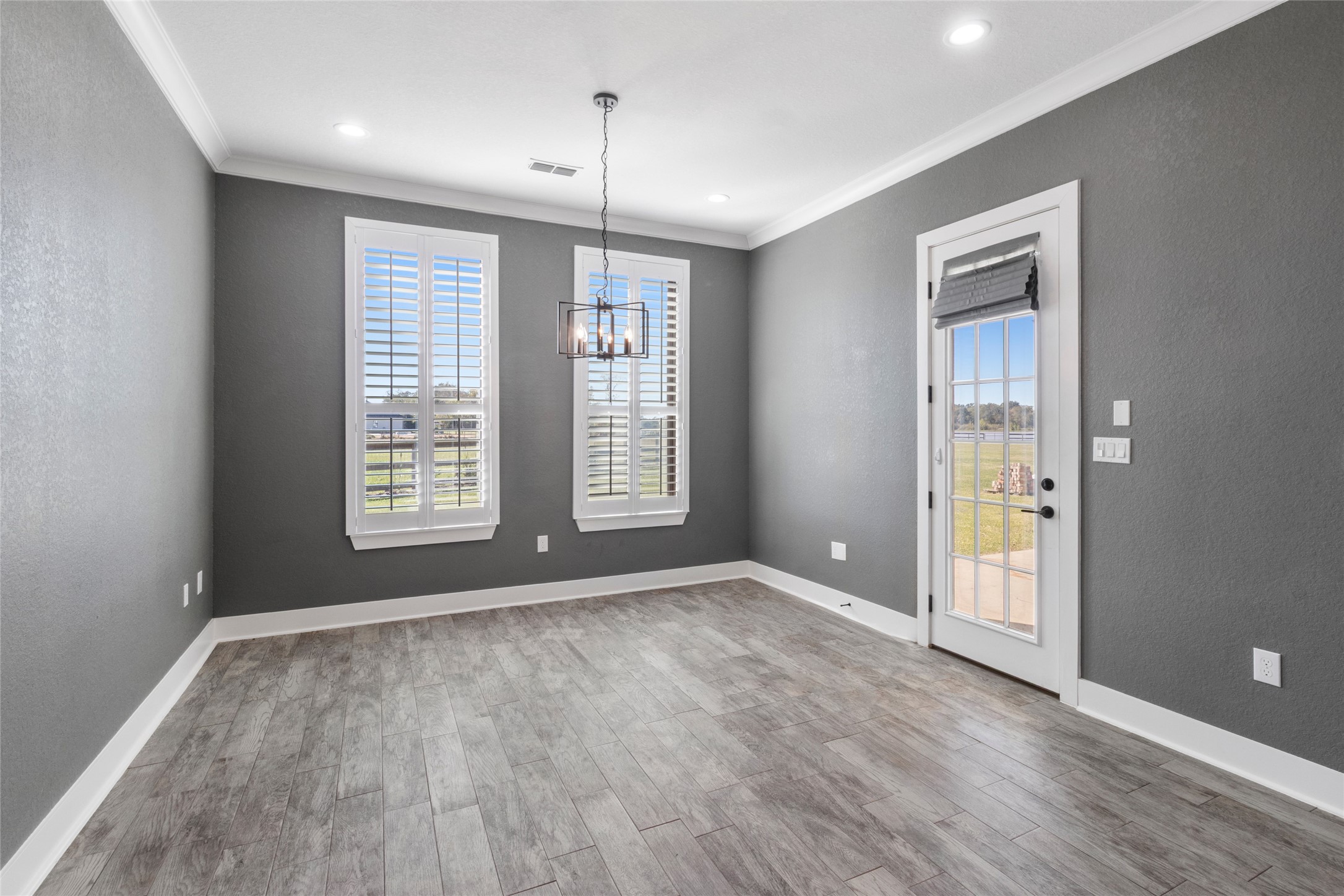 22010 Chenango Lake Drive Angleton, TX 77515 - Photo 10 of 43 an empty room with wooden floor and windows