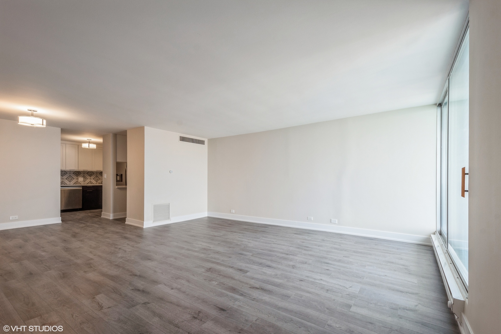 6033 North Sheridan Road, Unit 44D Chicago, IL 60660 - Photo 4 of 12 a view of an empty room with wooden floor and a window