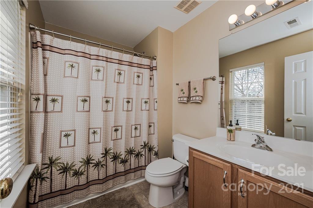11661 Coddington Ridge Drive Charlotte, NC 28214 - Photo 17 of 23 a bathroom with a granite countertop sink a toilet a mirror and shower curtain