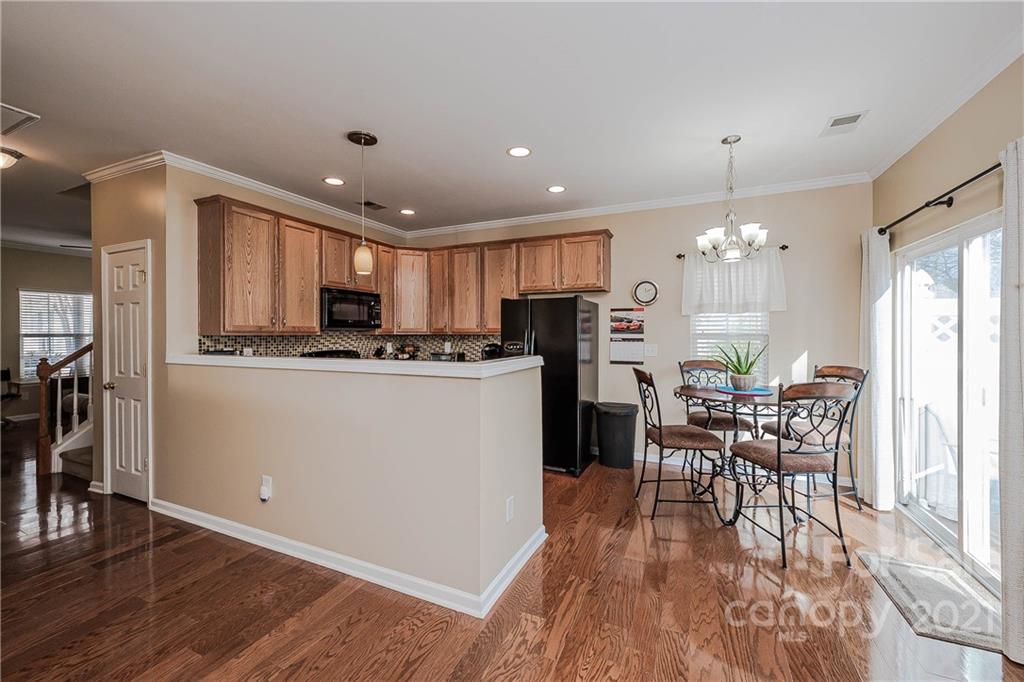 11661 Coddington Ridge Drive Charlotte, NC 28214 - Photo 9 of 23 a kitchen with refrigerator a dining table and chairs
