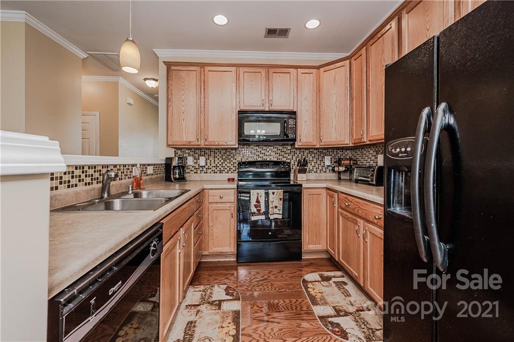 11661 Coddington Ridge Drive Charlotte, NC 28214 - Photo 10 of 23 a kitchen with stainless steel appliances granite countertop a stove top oven a sink and a refrigerator
