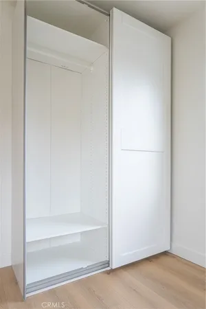a view of an empty room with a fireplace and wooden floor