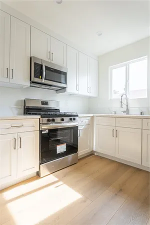 a kitchen with stainless steel appliances granite countertop a stove a sink and a microwave