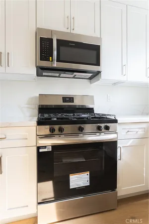 a kitchen with stainless steel appliances granite countertop a stove and a microwave