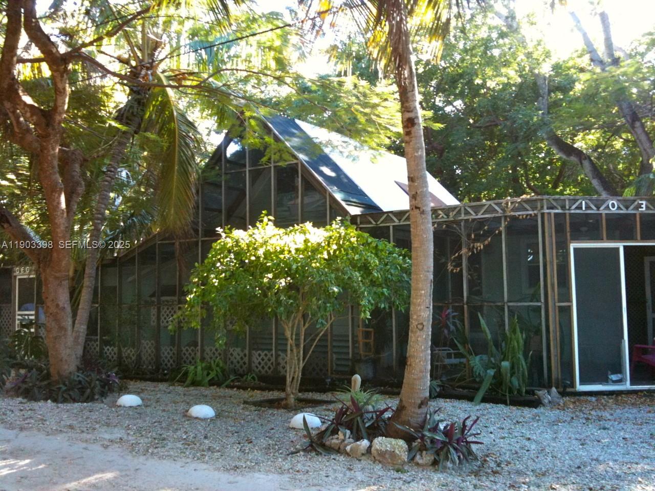 103 Tree Lane Tavernier, FL 33070 - Photo 3 of 33 a backyard of a house with lots of trees and plants