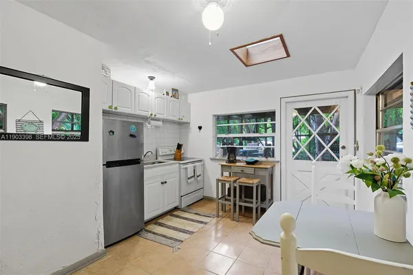 a kitchen with stainless steel appliances kitchen island granite countertop a refrigerator and a sink