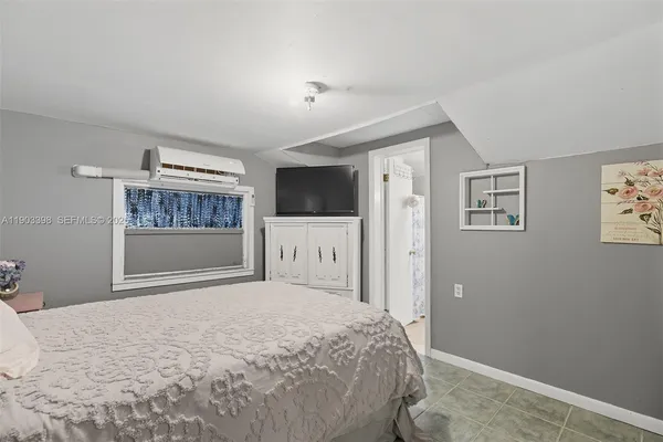 a bedroom with a bed and a flat screen tv