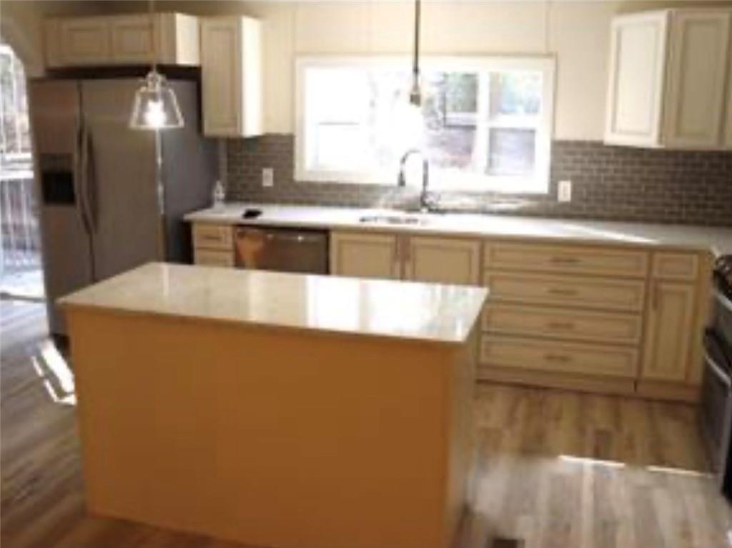 576 Nichols Road Pendergrass, GA 30567 - Photo 11 of 38 a kitchen with stainless steel appliances granite countertop a sink a stove and a refrigerator