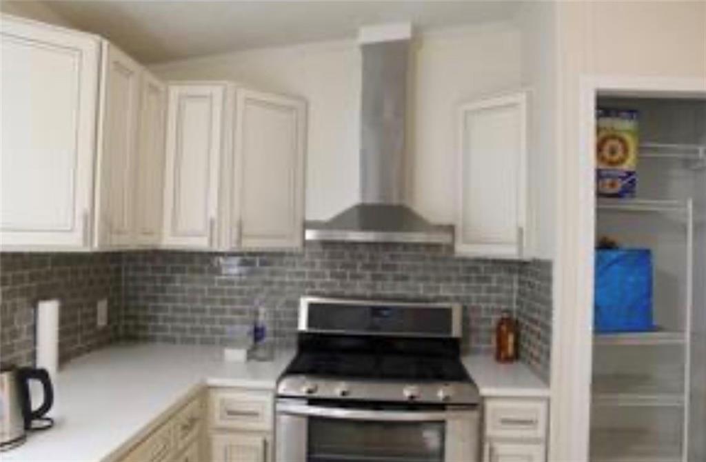 576 Nichols Road Pendergrass, GA 30567 - Photo 12 of 38 a kitchen with a stove and white cabinets
