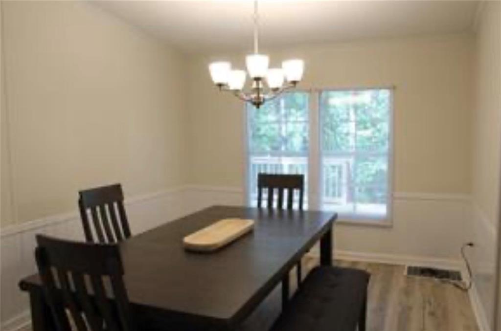 576 Nichols Road Pendergrass, GA 30567 - Photo 13 of 38 a view of a dining room with furniture a chandelier and wooden floor