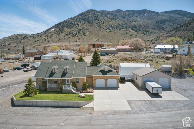 151 South Haulage Road Eureka, UT 84628 - Photo 3 of 36 View of front of house with a porch, a mountain view, brick siding, concrete driveway, and an attached garage