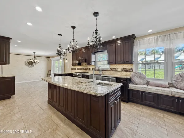 a kitchen with stainless steel appliances granite countertop a sink counter space cabinets and a wooden floor