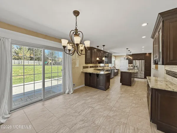 a open kitchen with stainless steel appliances kitchen island granite countertop a stove top oven a sink and cabinets