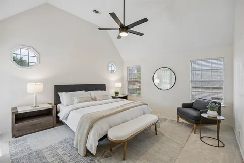 a bedroom with a bed a chair and a chandelier