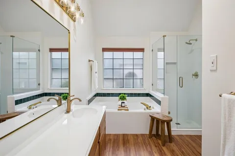 a bathroom with a tub sink and mirror