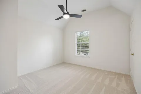 an empty room with a window and a fan