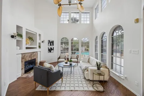 a living room with fireplace furniture and a floor to ceiling window