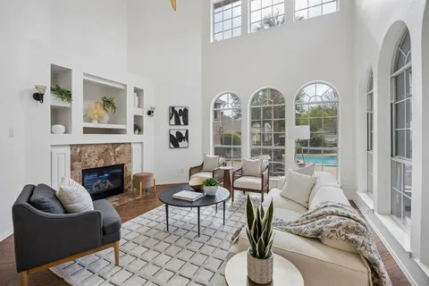 a living room with furniture a fireplace and a floor to ceiling window