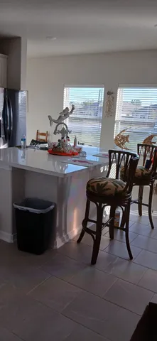 a room with a table chairs and a refrigerator