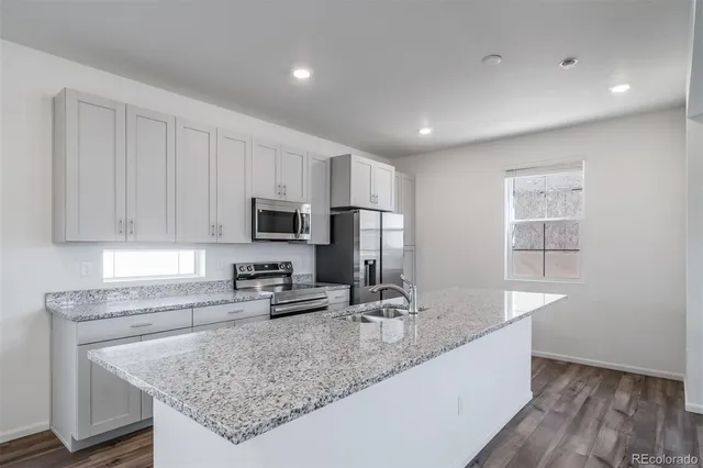 a kitchen with stainless steel appliances granite countertop a sink stove and refrigerator