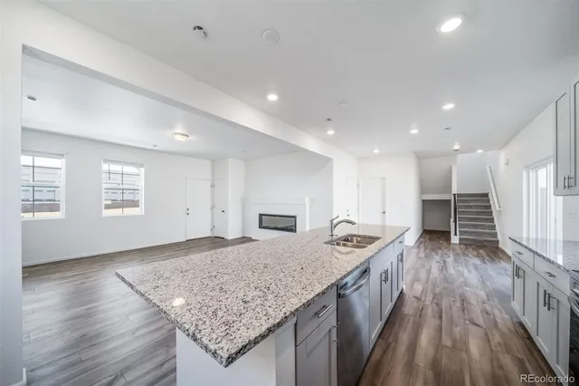 a kitchen with granite countertop kitchen island a stove a counter space and wooden floor