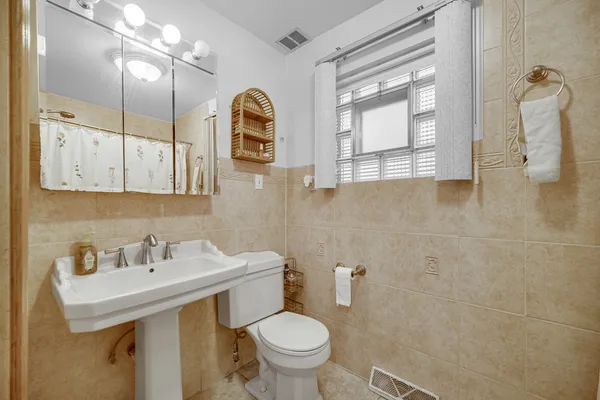 a bathroom with a sink a toilet and mirror