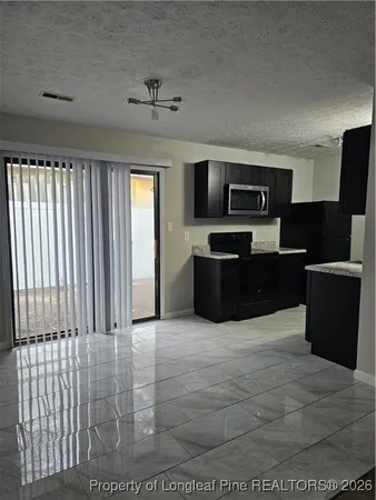 a view of kitchen with kitchen island microwave and refrigerator