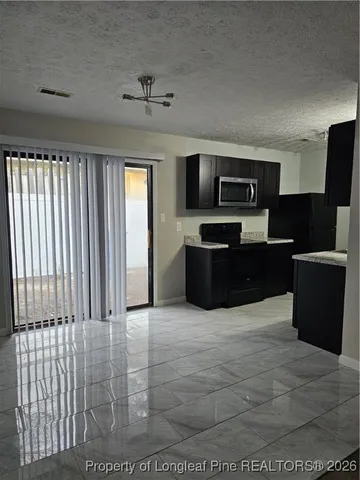 a view of kitchen with kitchen island microwave and refrigerator