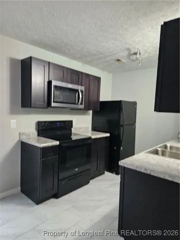 a kitchen with a refrigerator and a stove