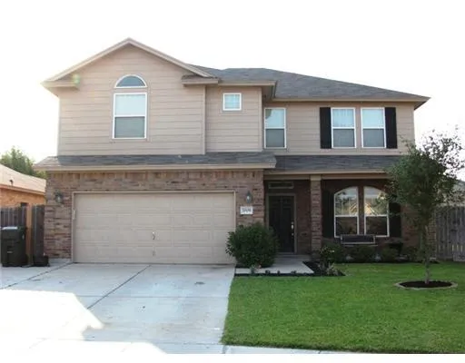 a front view of a house with a garden and garage