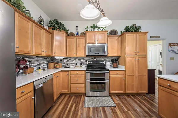 a kitchen with granite countertop a refrigerator stove and sink