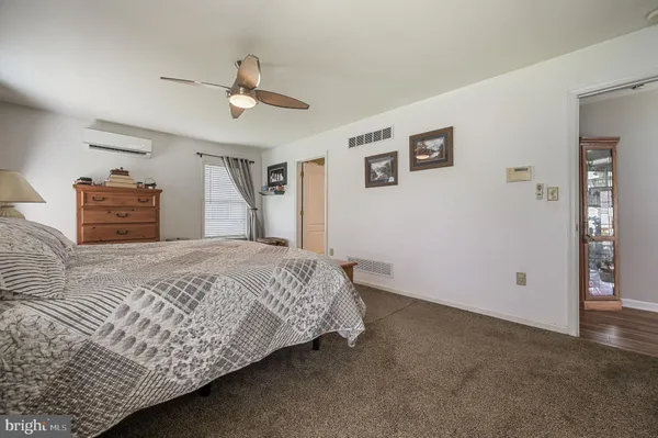 a bedroom with a large bed and a chandelier fan
