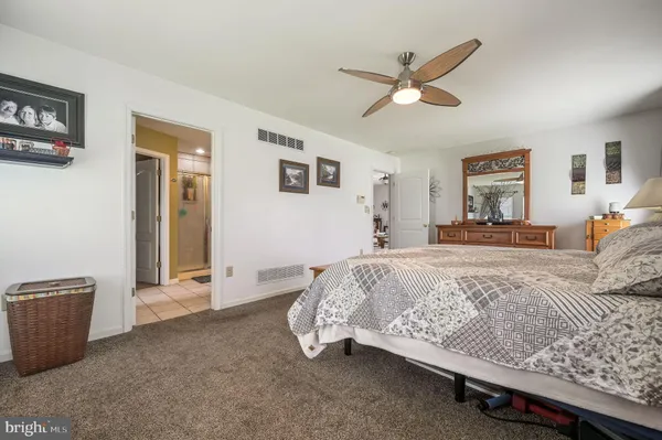 a bed room with a bed and a ceiling fan