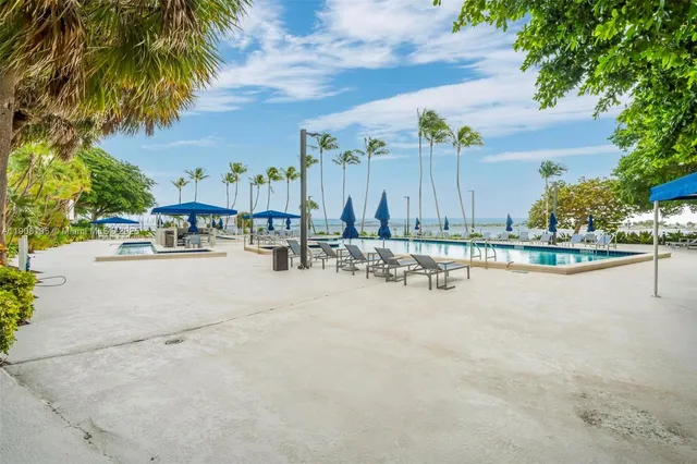 a view of a tennis ground with large trees