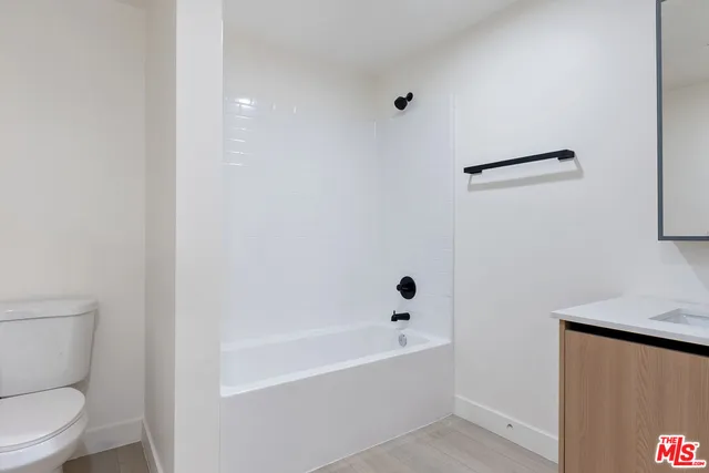 a white toilet sitting next to a bath tub
