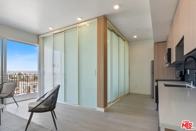 a view of a hallway with furniture and a kitchen