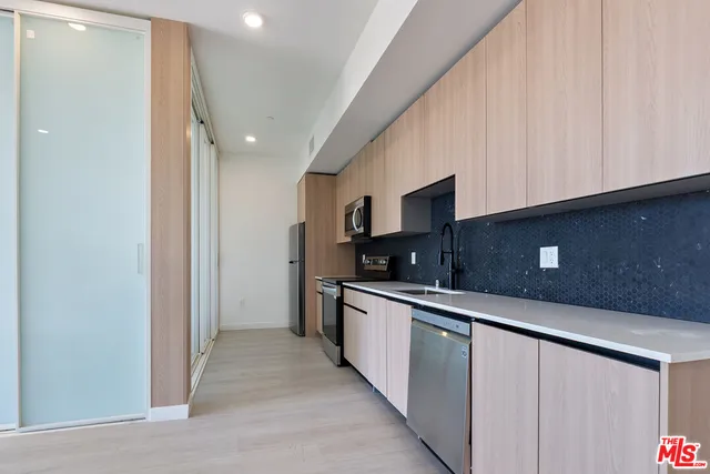a kitchen with stainless steel appliances a sink a stove and cabinets
