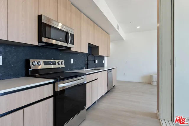 a kitchen with stainless steel appliances granite countertop a stove and a microwave