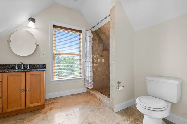 a bathroom with a granite countertop toilet sink and mirror