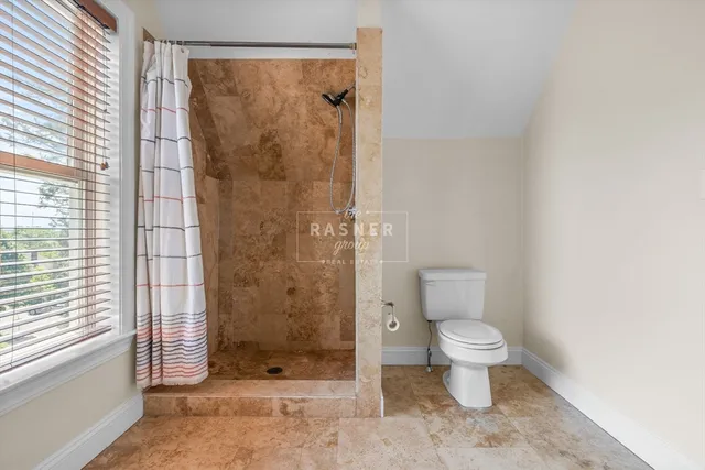 a bathroom with a toilet and a shower