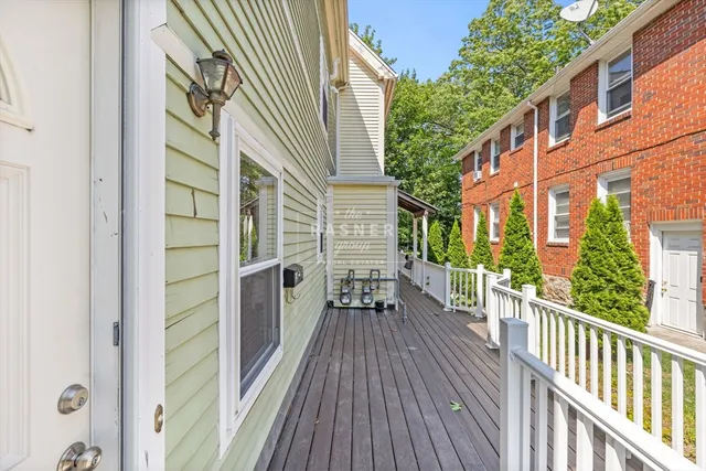 a view of a balcony with wooden floor and fence and a floor to ceiling window