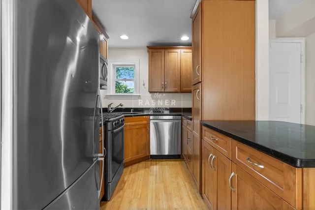 a kitchen with granite countertop white cabinets and refrigerator