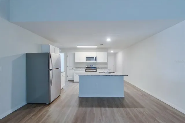 a kitchen with stainless steel appliances a refrigerator and a stove top oven
