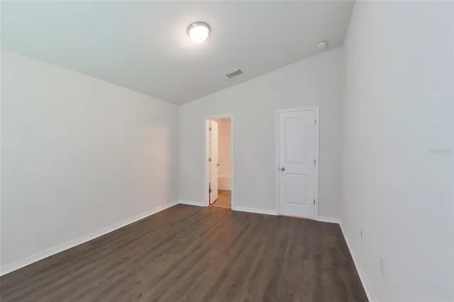 an empty room with wooden floor and white walls