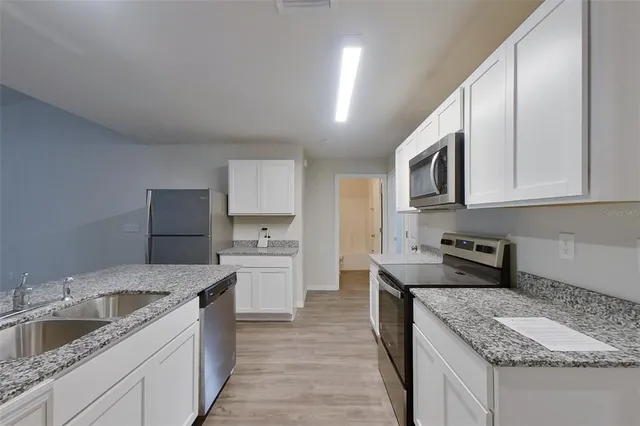 a kitchen with stainless steel appliances granite countertop a sink stove and refrigerator