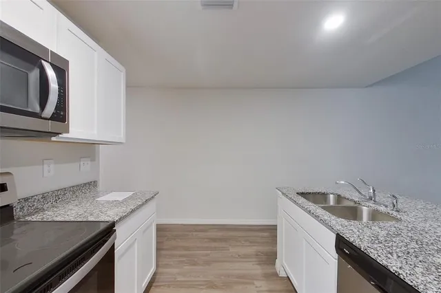 a kitchen with granite countertop cabinets stainless steel appliances and a sink