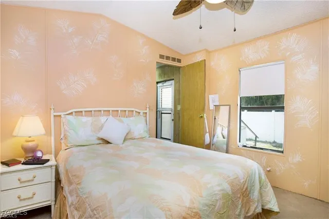 a large bed sitting in a bedroom next to a window