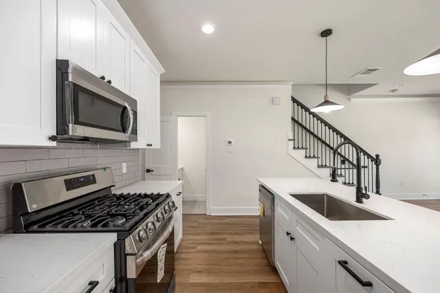 a kitchen with stainless steel appliances granite countertop a sink stove and microwave