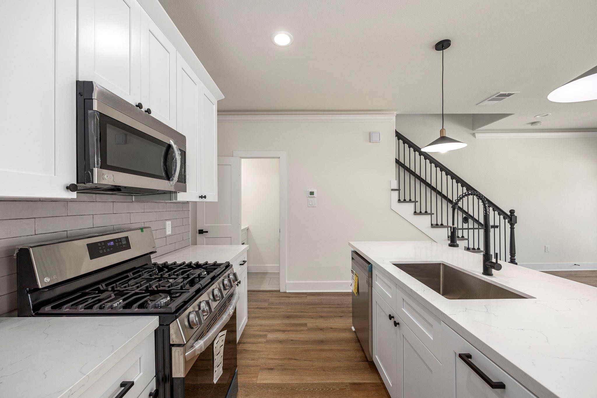 911 Panama Street Houston, TX 77009 - Photo 3 of 10 a kitchen with stainless steel appliances granite countertop a sink stove and microwave
